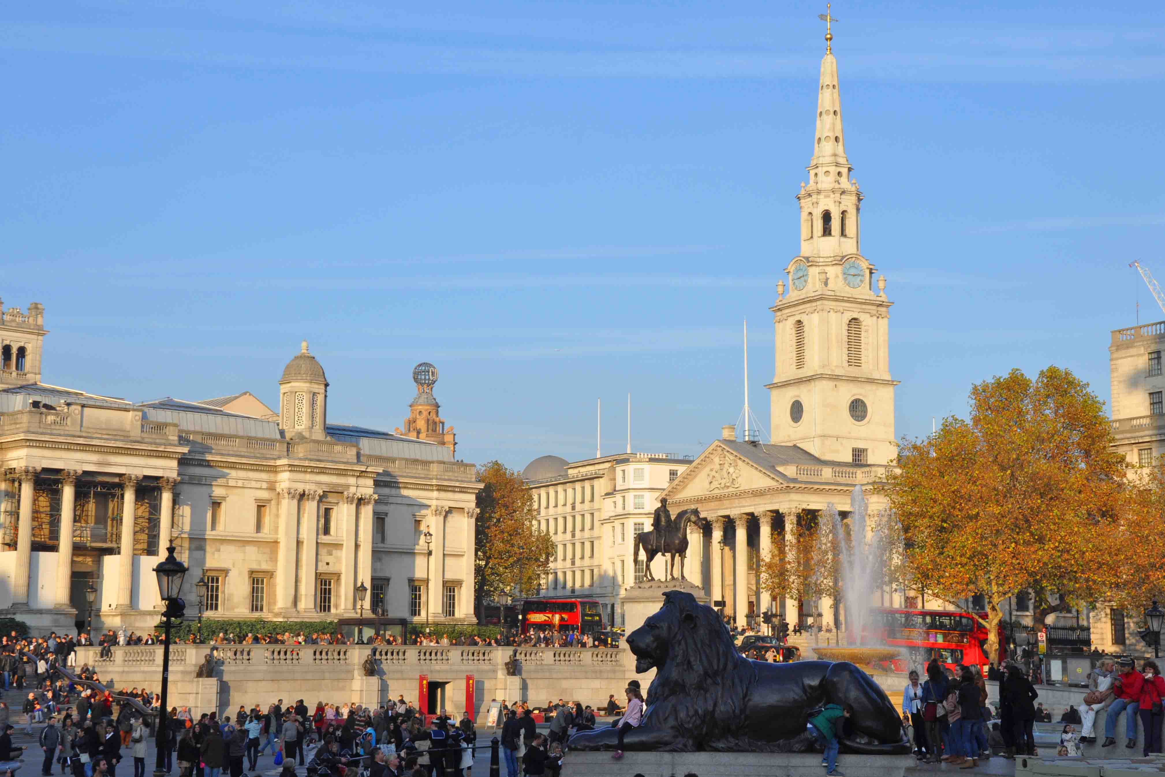 Trafalgar Square with lion sculpture and lots of people