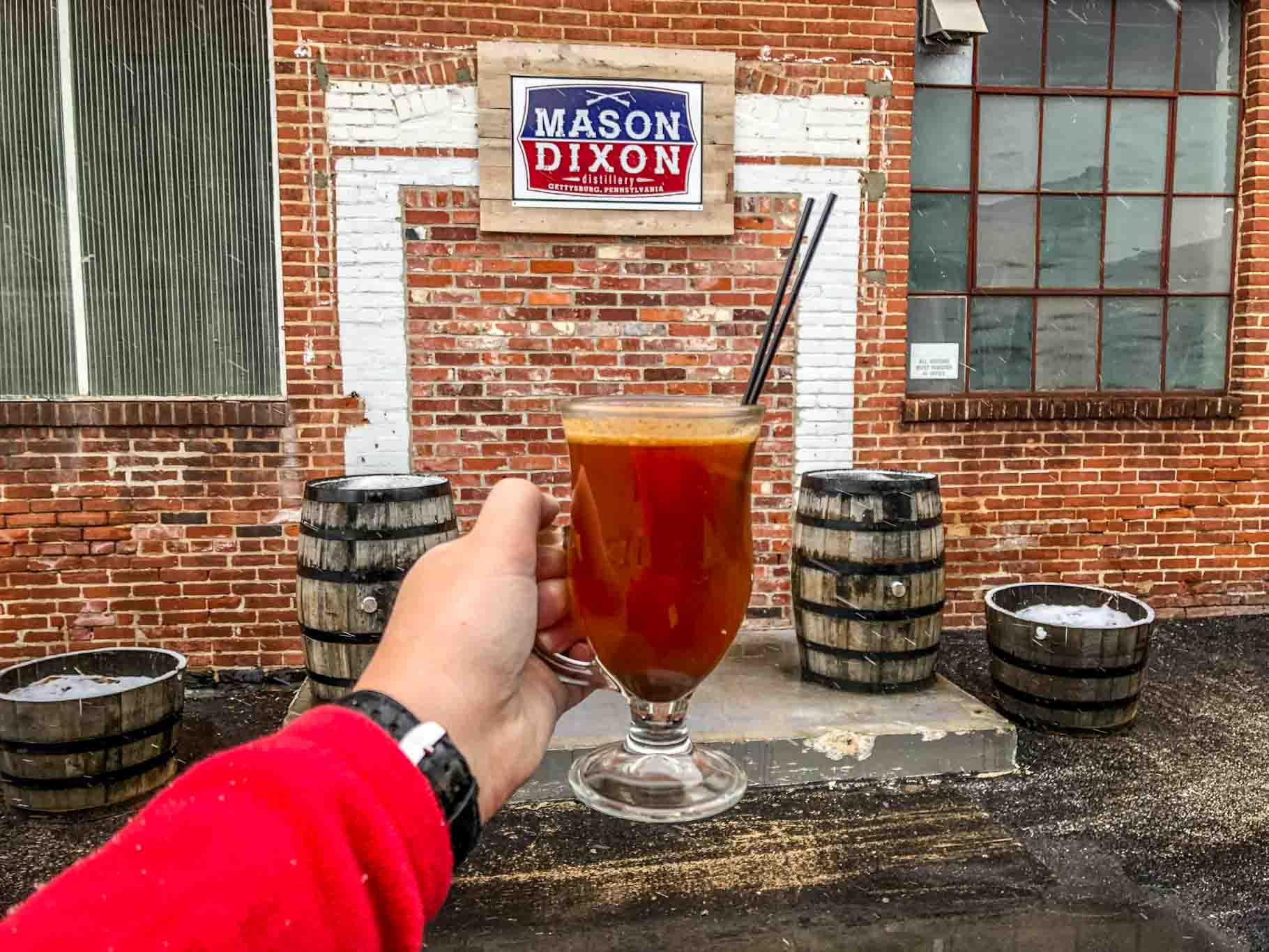 Cocktail in front of sign for Mason Dixon Distillery in Gettysburg PA