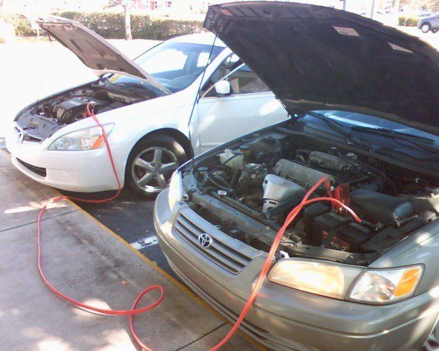 Using jumper cables to do an emergency start start of a car. They are an important item to have in your roadside emergency kit.