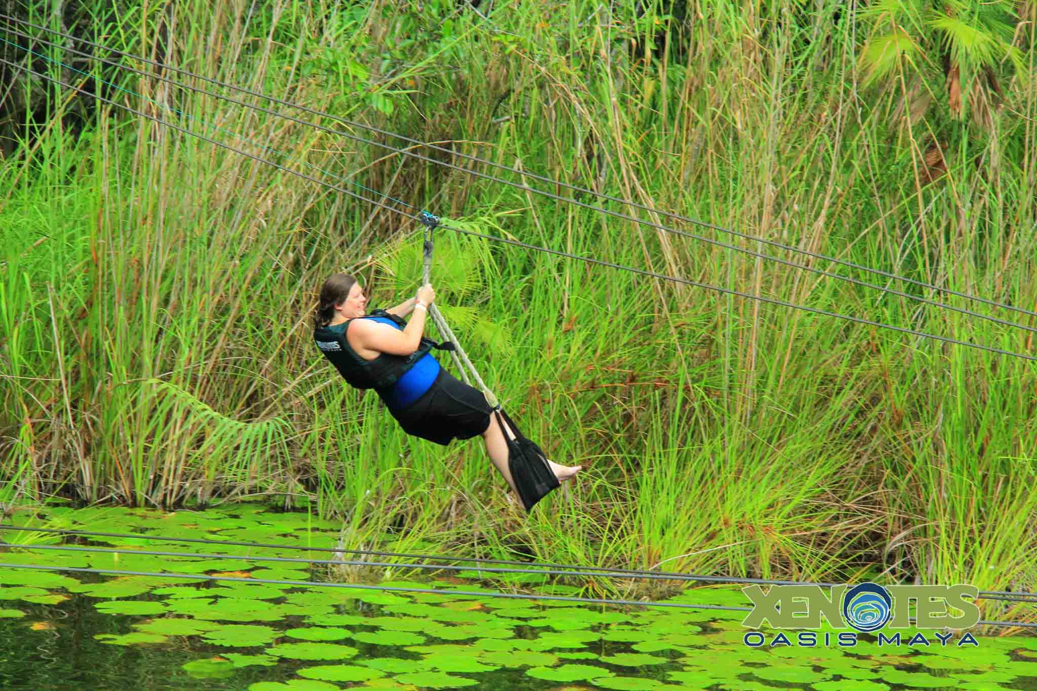 Laura on a zip line in Mexico over a cenote on a Solo travel trip.