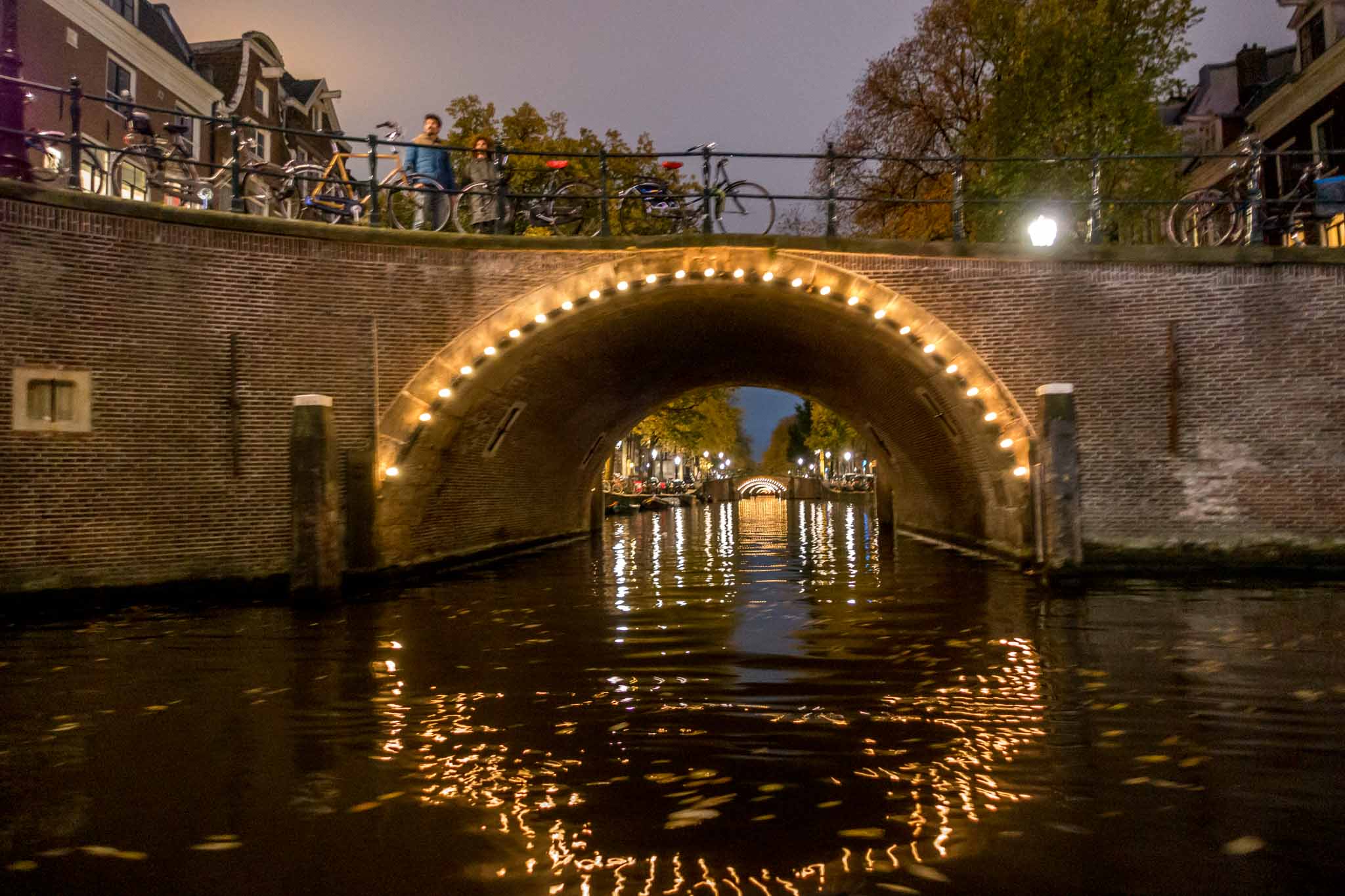 Illuminated bridge over a canal at night