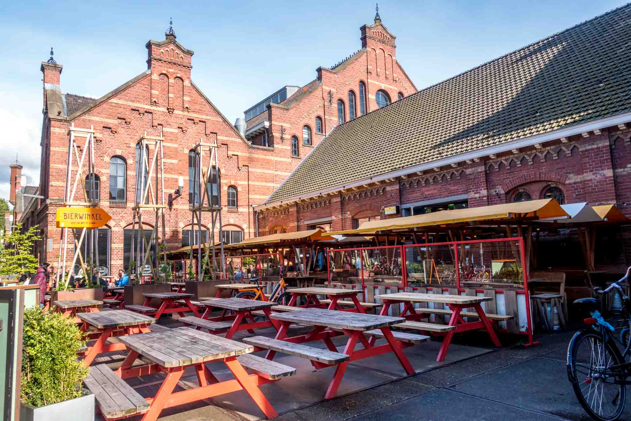 Troost Brewery outdoor seating and the red brick buildings of Westergasfabriek, one of the best spots in Amsterdam to enjoy the park and cafes