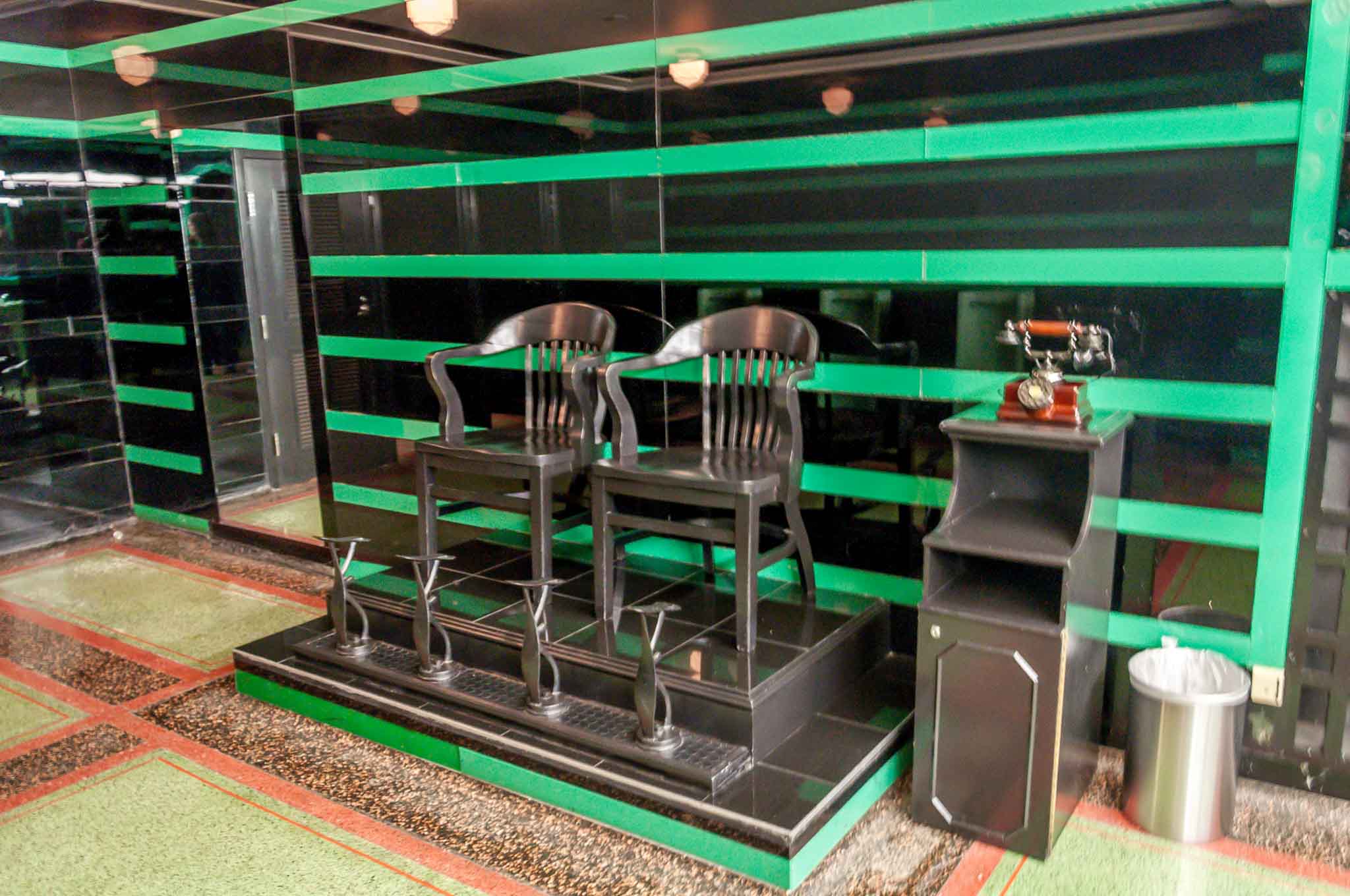 Two black chairs in front of a black and green wall in America's best restroom at the Hermitage Hotel, one of the favorite Nashville attractions