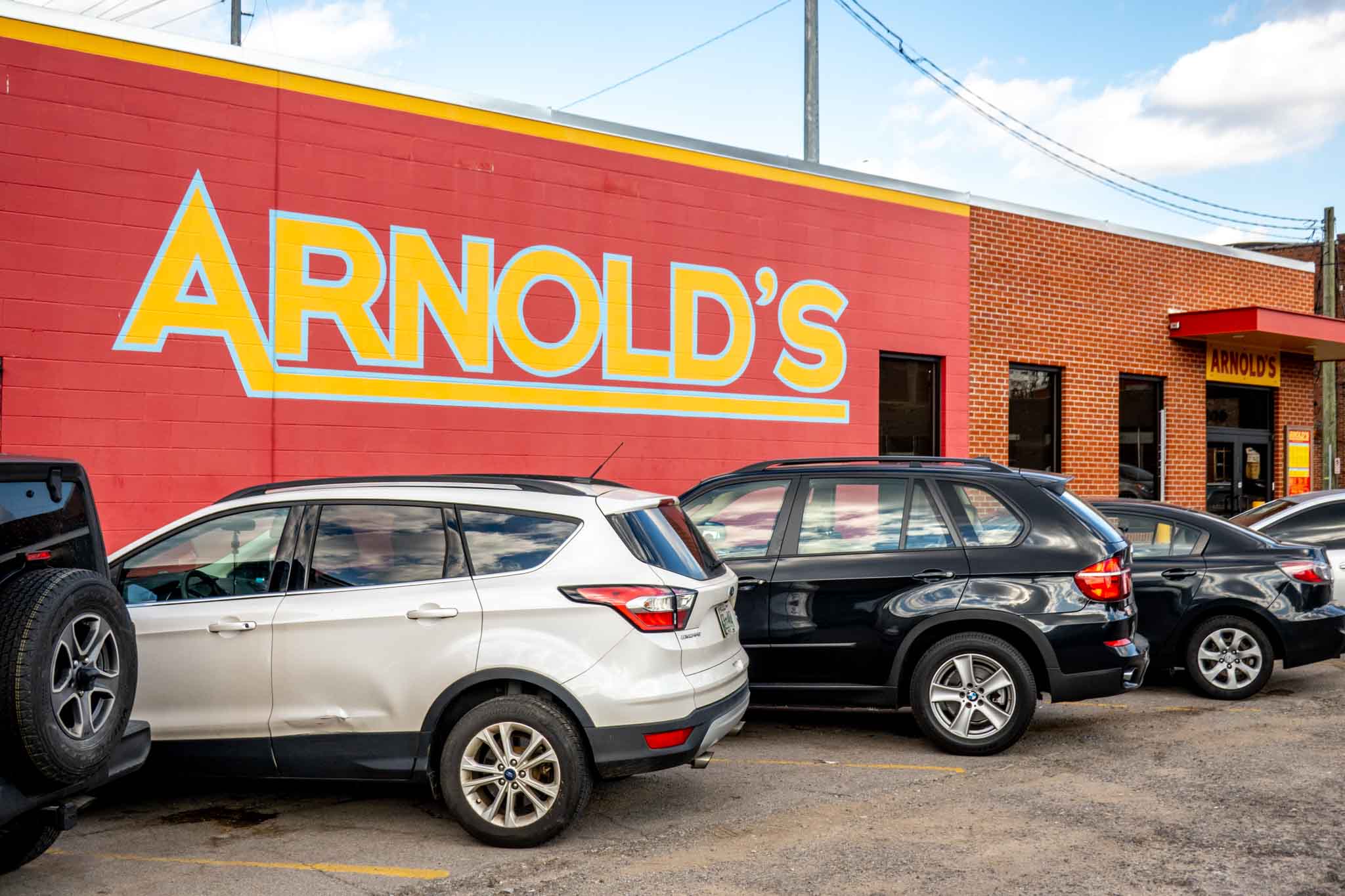 Yellow and red sign for Arnold's restaurant pained on a brick wall