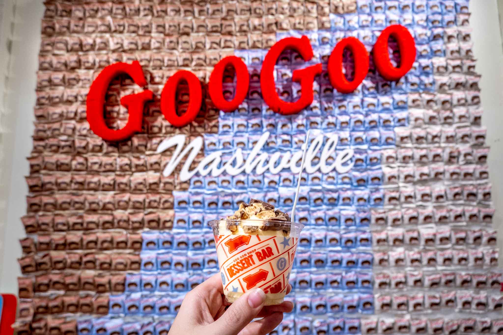 Ice cream topped with chopped Goo Goo Clusters in front of decorated wall in Nashville