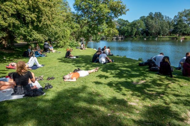 People relax by the lake in Copenhagen's Christiania commune