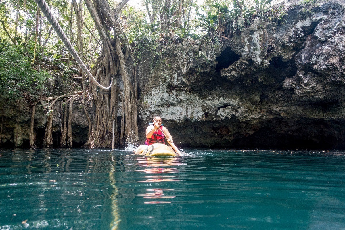 Paddling on a kayak in a open cenote on the Ruta de los Cenotes.