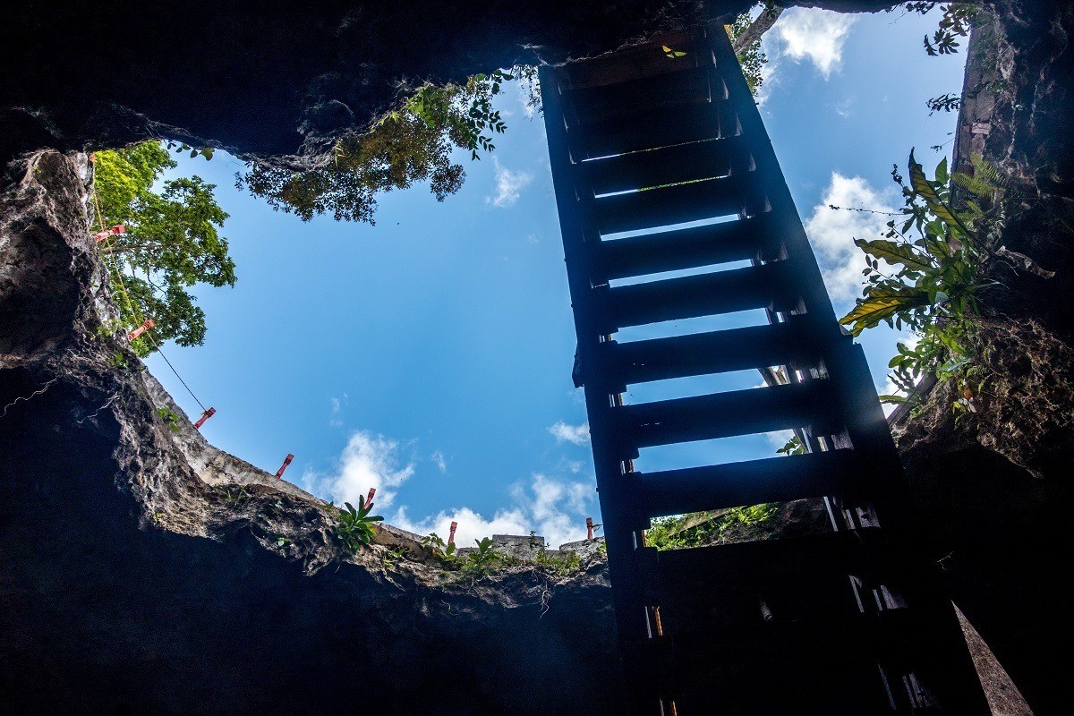 Looking up at the sky from inside a closed cenote.