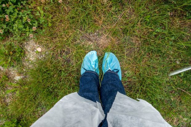 Putting on shoe covers and a smock to enter a Parmigiano-Reggiano dairy in Italy