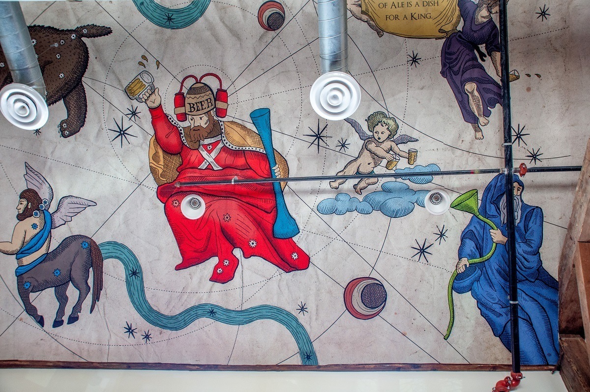 Ceiling mural showing cherubs and a man drinking from a beer helmet