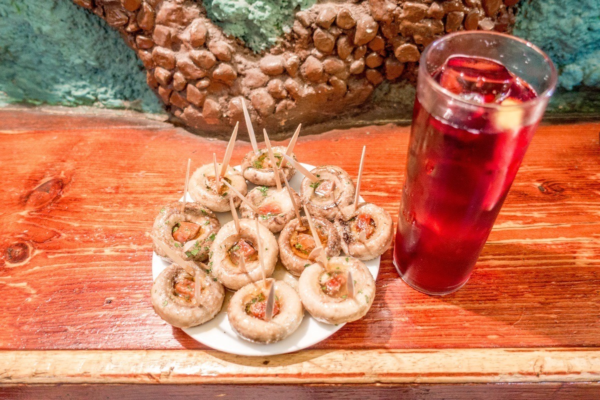 Mushrooms stuffed with chorizo and tinto de verrano on a food tour in Madrid, Spain