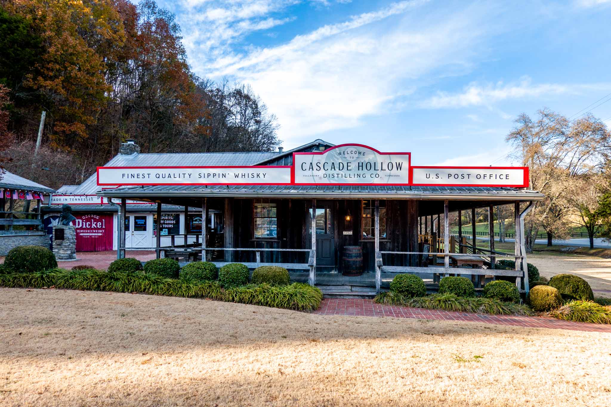 Large building with a wooden front porch at Cascade Hollow Distilling
