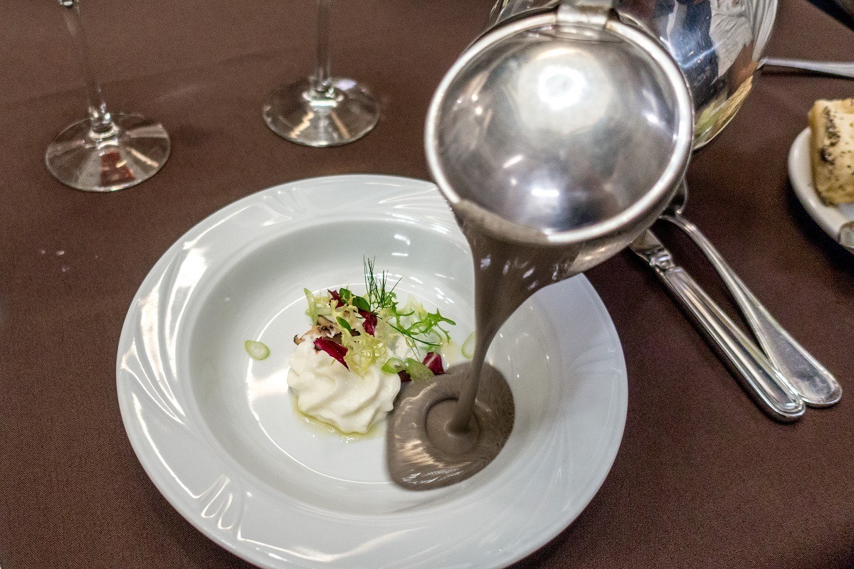 Mushroom bisque soup being poured into a bowl