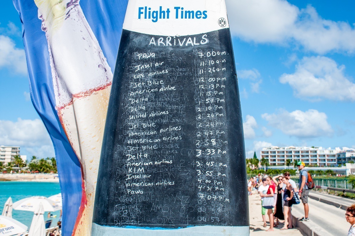 Schedule of planes landing at Maho Beach written on a surfboard