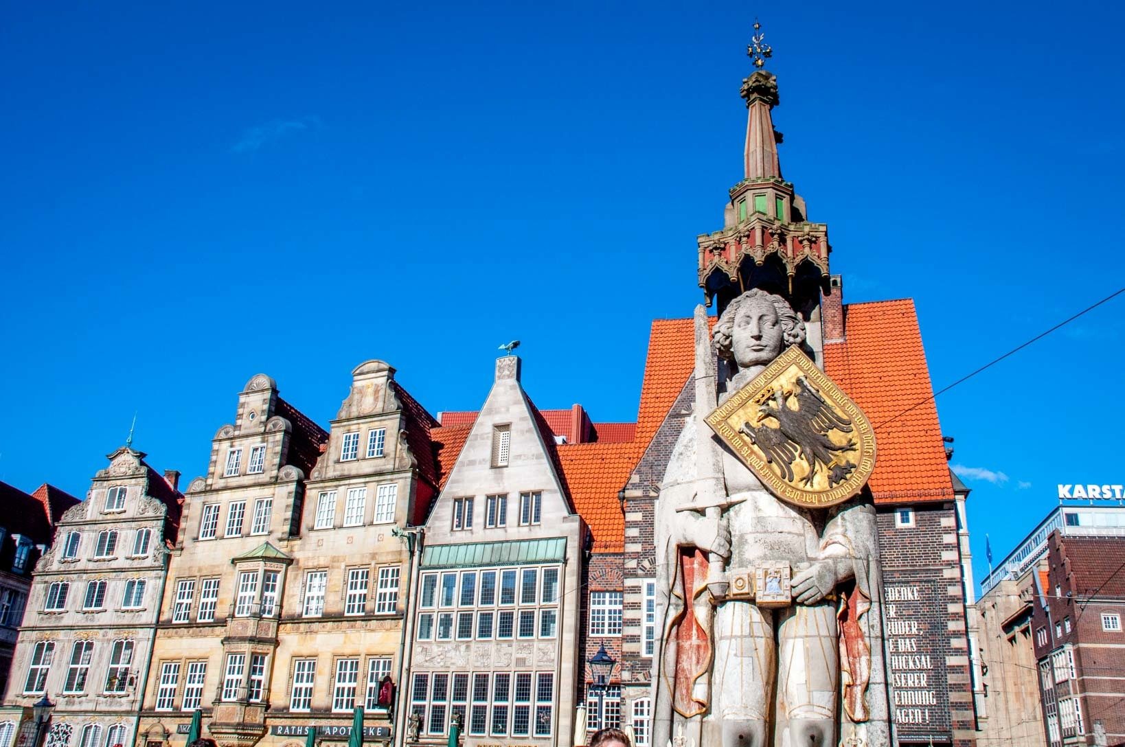 The old merchant houses of Market Square behind the Bremen Roland statue, a 15th-century statue of a man holding a sword and shield are must-sees when you visit Bremen, Germany