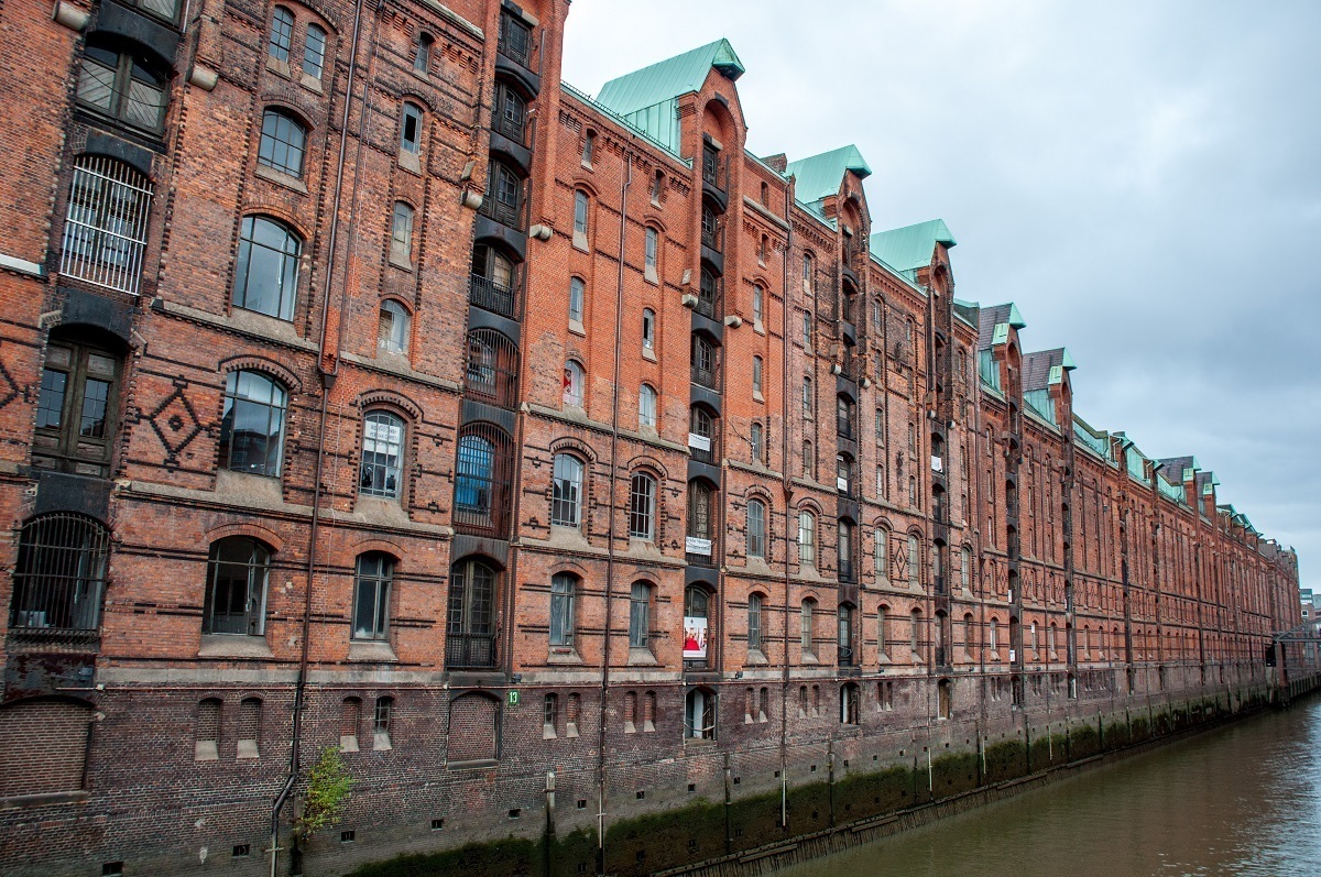 Long line of red-brick warehouses over a canal, part of the Speicherstadt district
