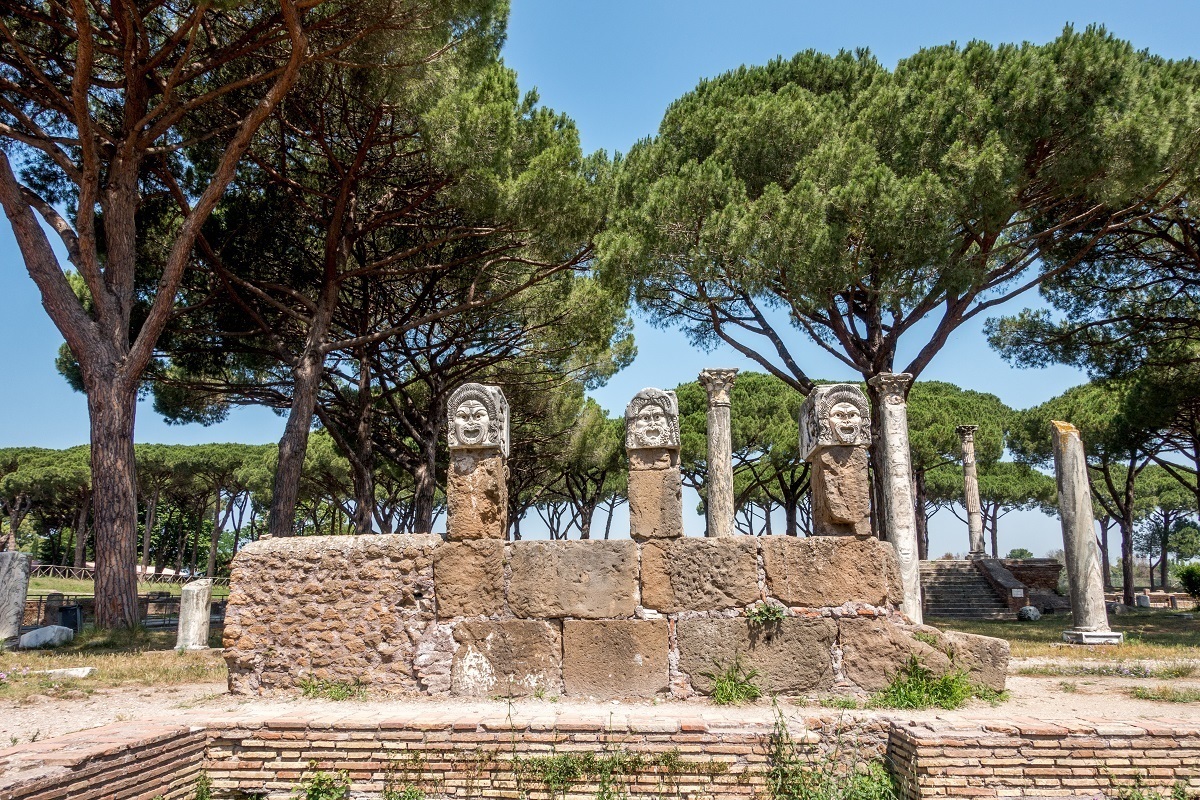 Theatrical masks on top of columns near the theater