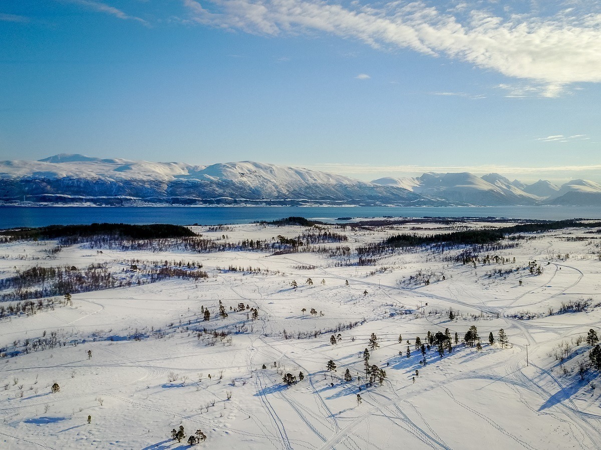 Snow-covered landscape with hills and ocean