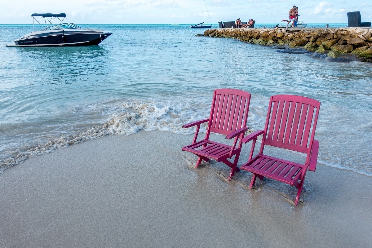 Beach chairs on the beach in Antigua near a rock jetty