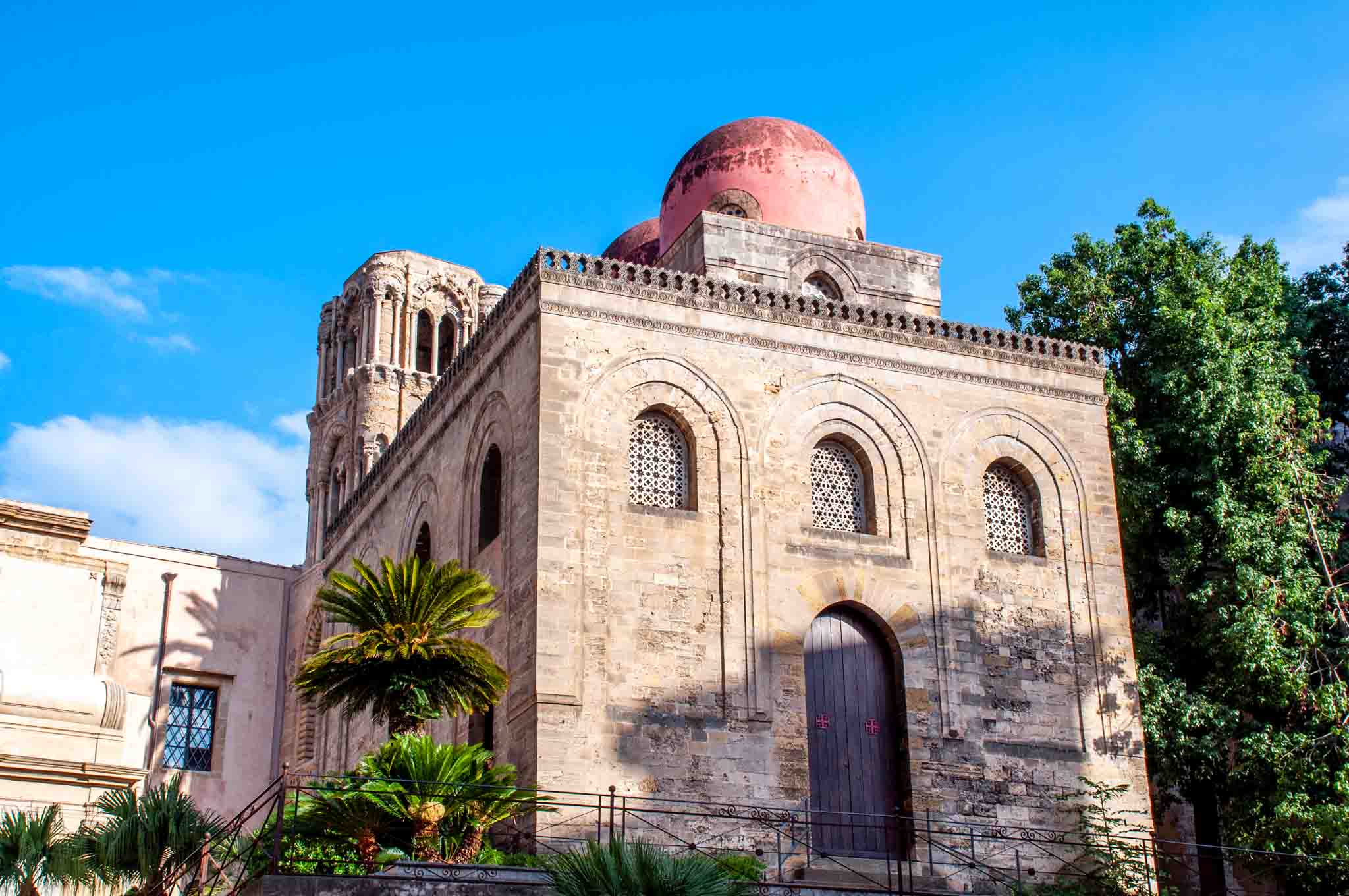 Exterior of the square-shaped Church of San Cataldo topped with three red domes
