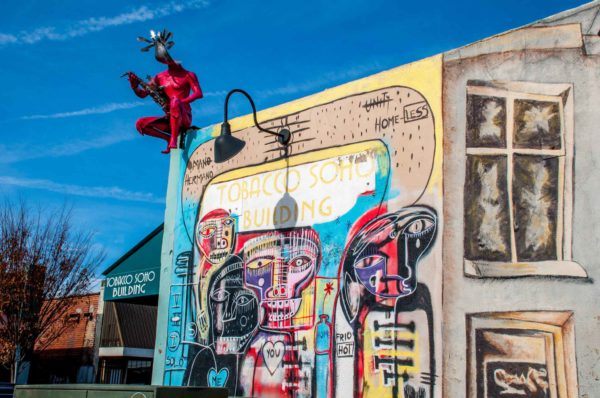 Winston-Salem-NC-Tobacco-Soho-mural Street art mural showing colorful figures on the Tobacco Soho Building in Winston Salem NC
