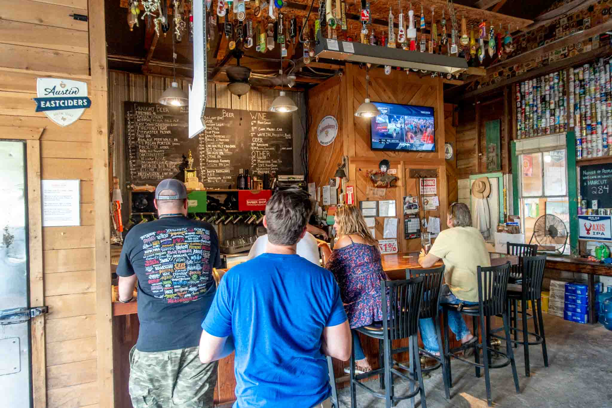 People ordering beer and sitting at the bar at the Barber Shop, a popular beer bar in Dripping Springs, Texas