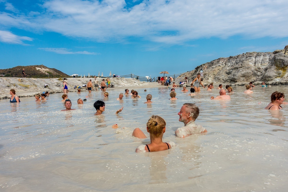 People soaking in a mud bath on a volcano in Italy