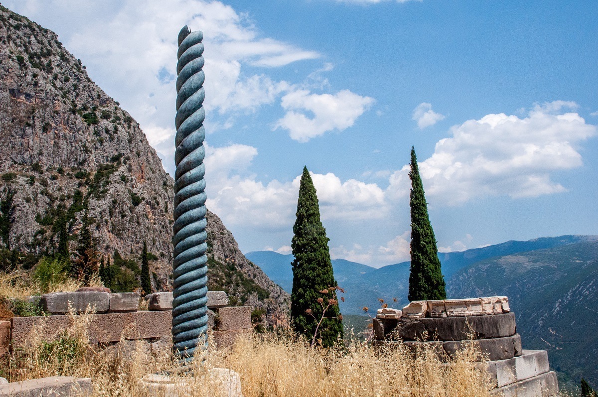 The recreation of the Serpent Column at the Sanctuary of Apollo Delphi. Visiting Delphi is one of the best day trips from Athens Greece.