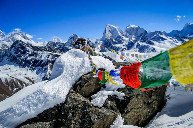 Trekking in Nepal Himalaya Photos: Prayer flags on Annapurna. What is trekking? It is an extended multi-day hike where sherpas carry your gear. Photo courtesy of Susan Green.