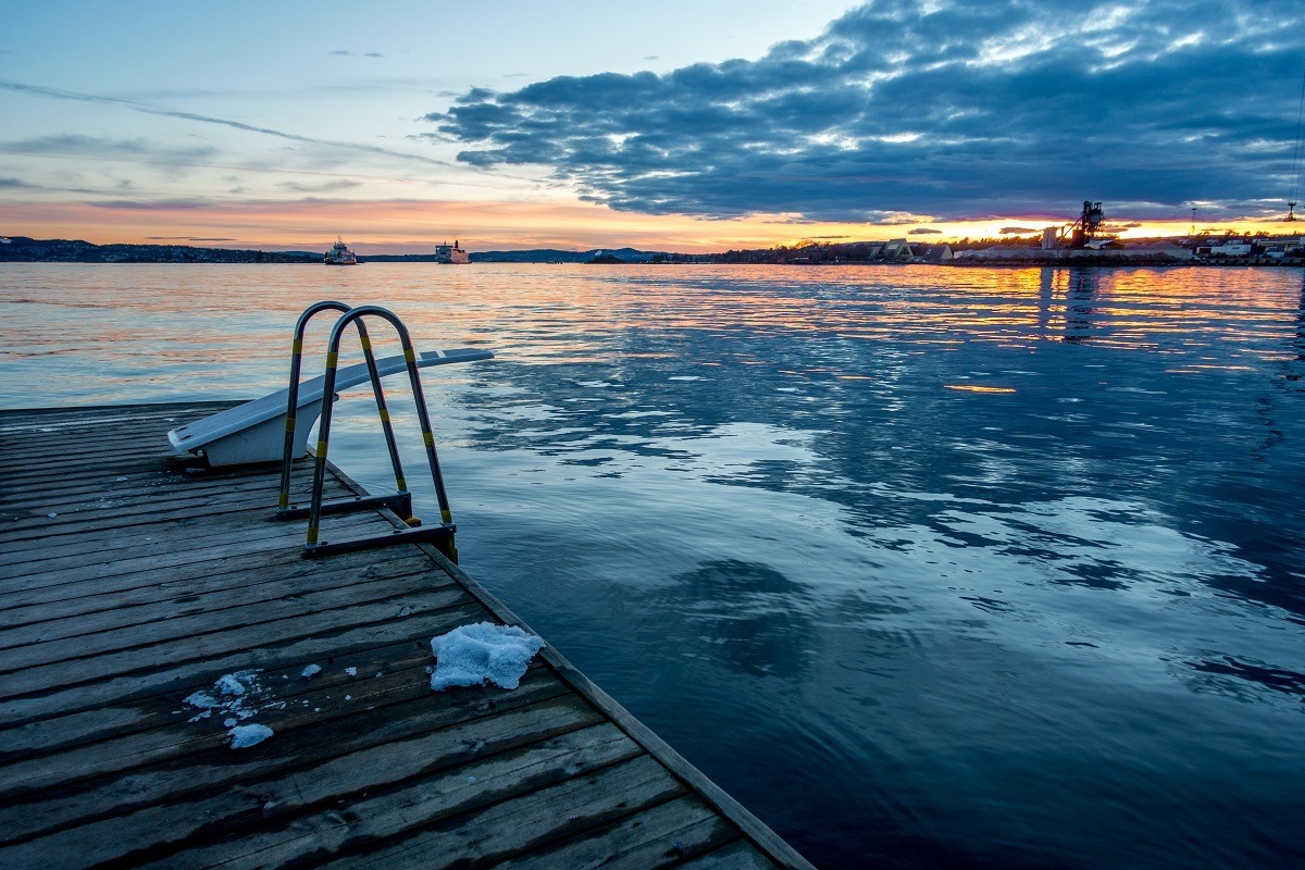 Diving board and ladder into the ocean at Tjuvholman Bath with snow on the dock