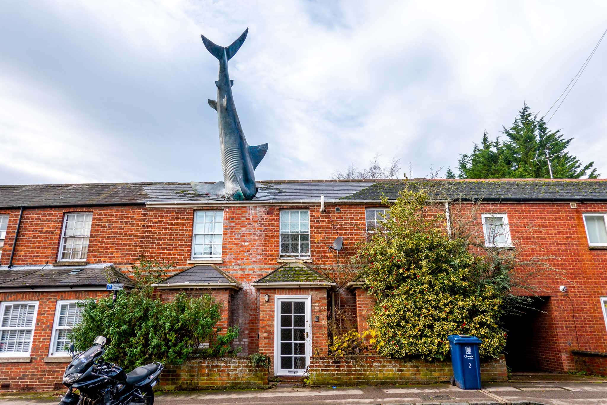 25-foot--long shark sculpture protruding from the roof of a home, the Headington Shark
