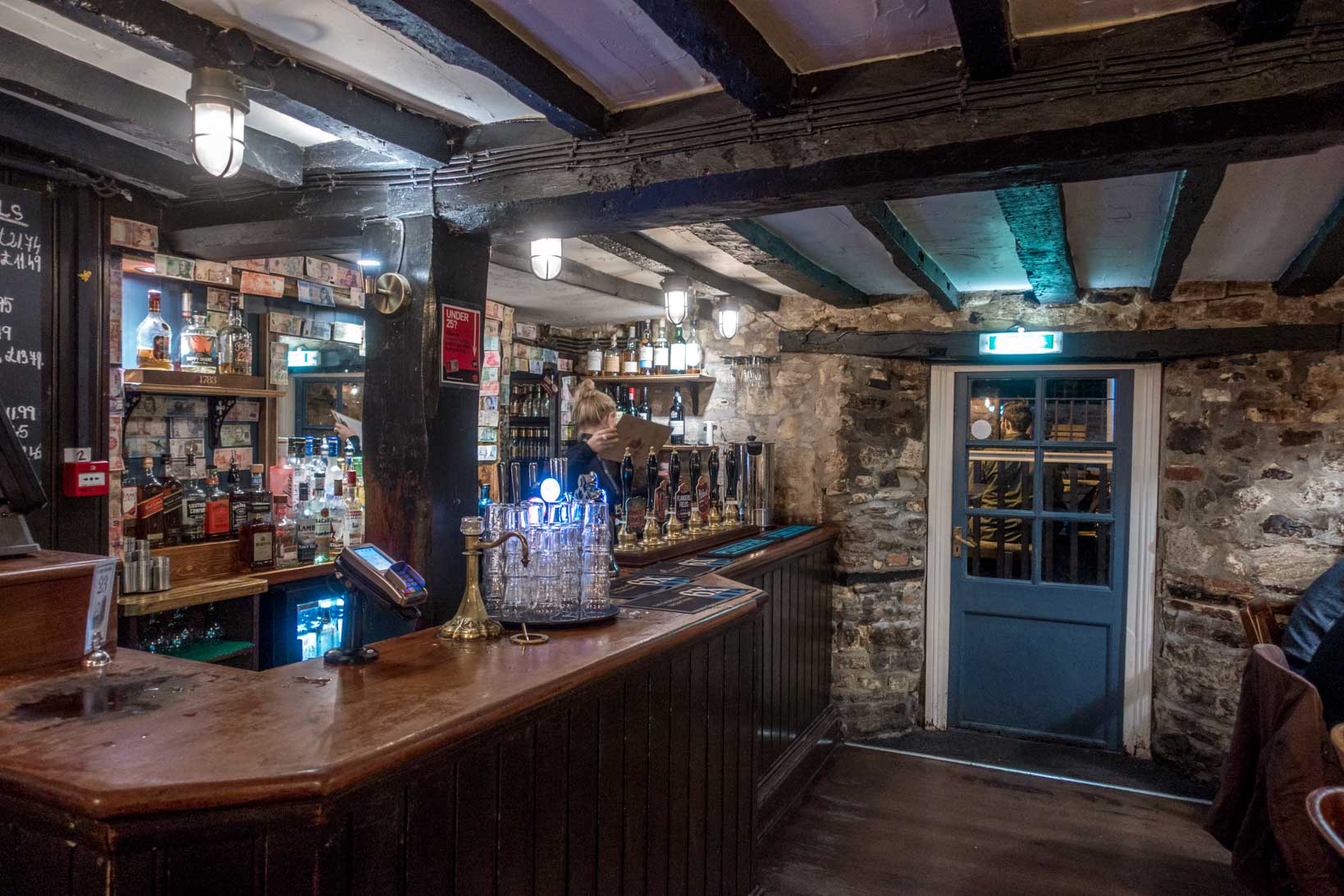 Bar, stone walls, and old wooden beams inside the historic Turf Tavern in Oxford, England