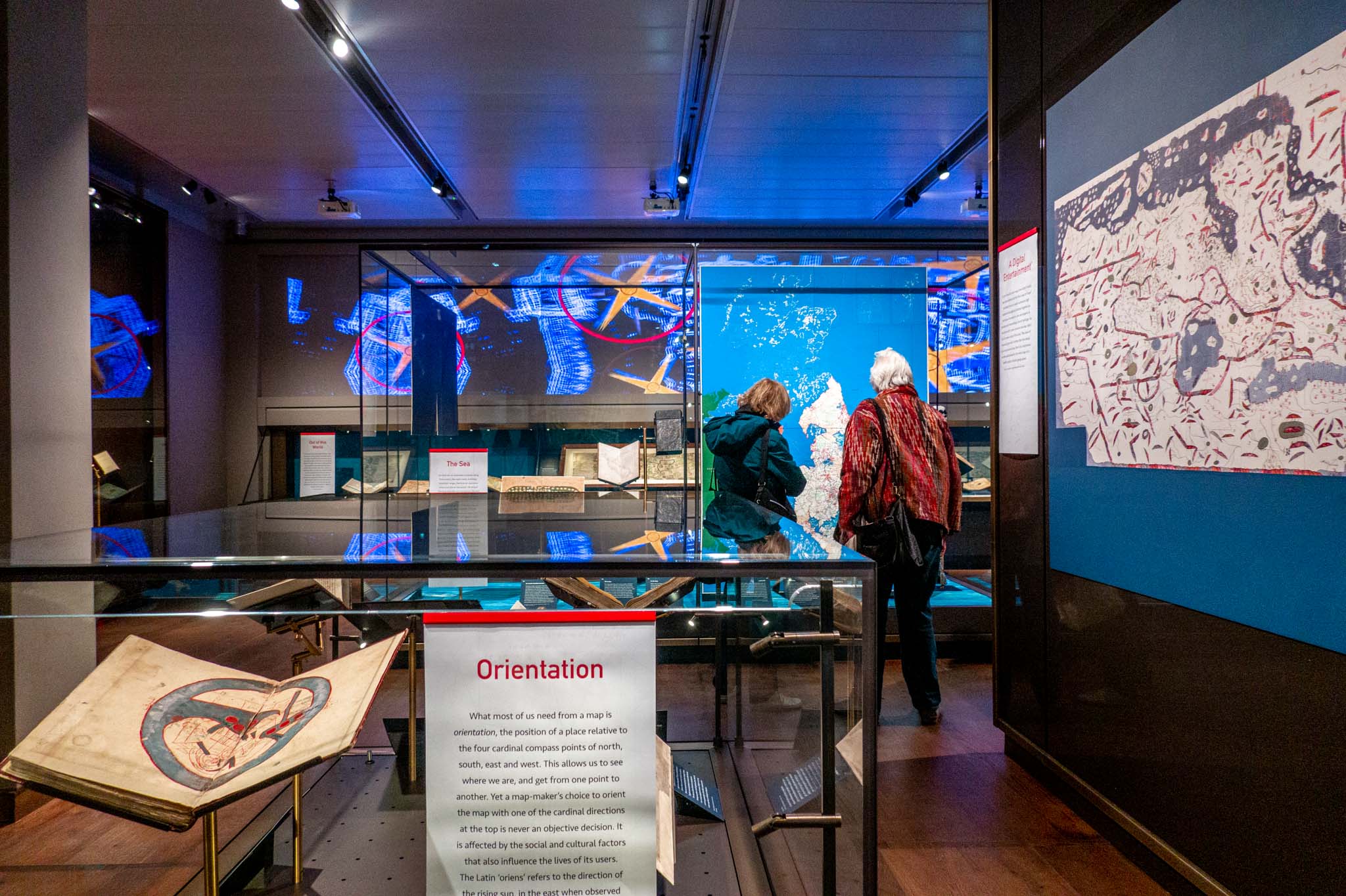 People reading display panels in exhibit rooms