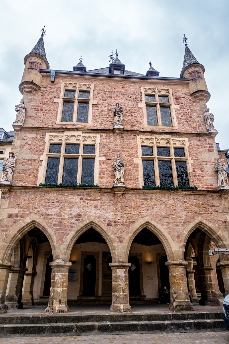 Stone building with sculptures and arched entryway, the Denzelt in Echternach