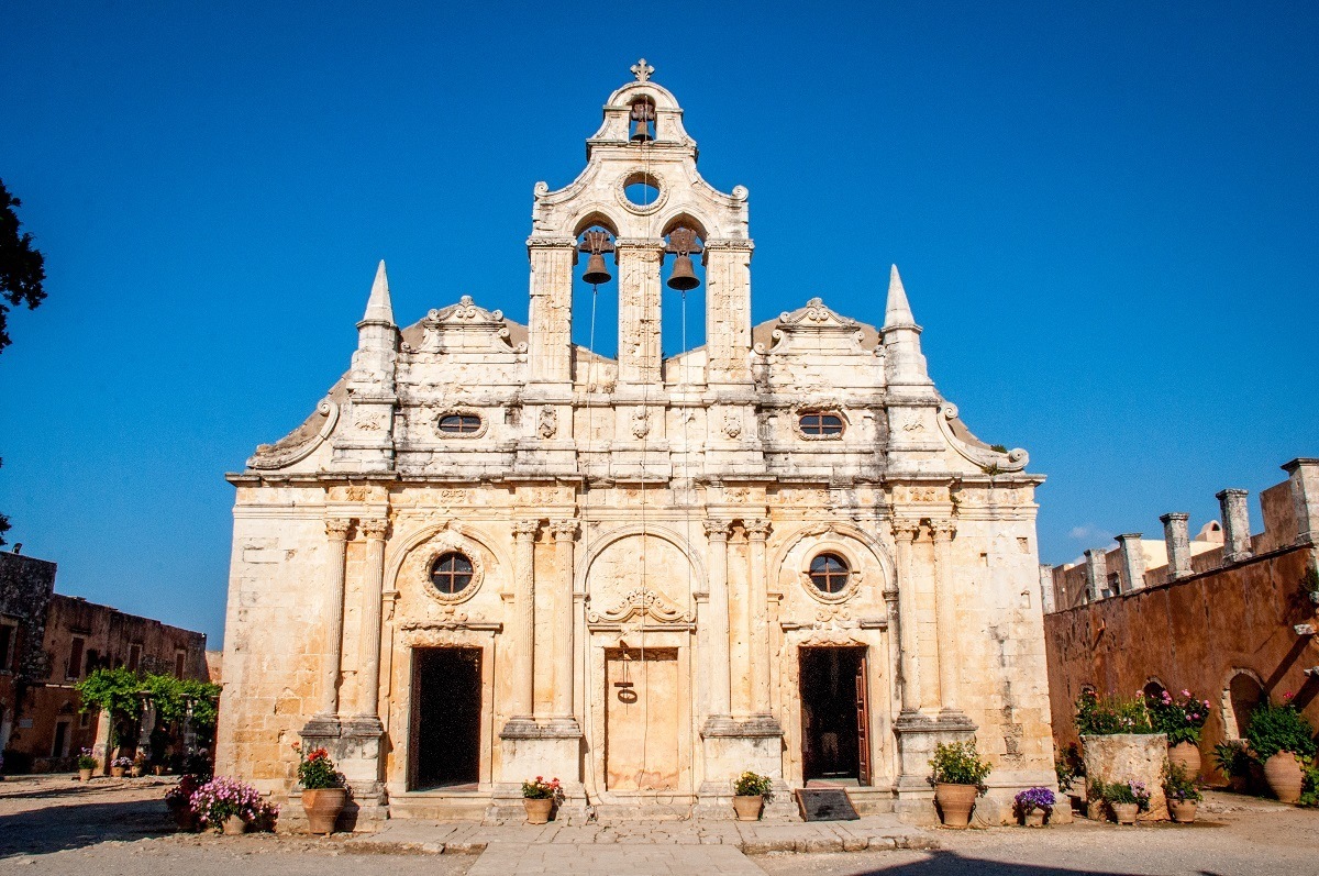 Yellow stone fascade and bells at the historic Arkadi Monastery