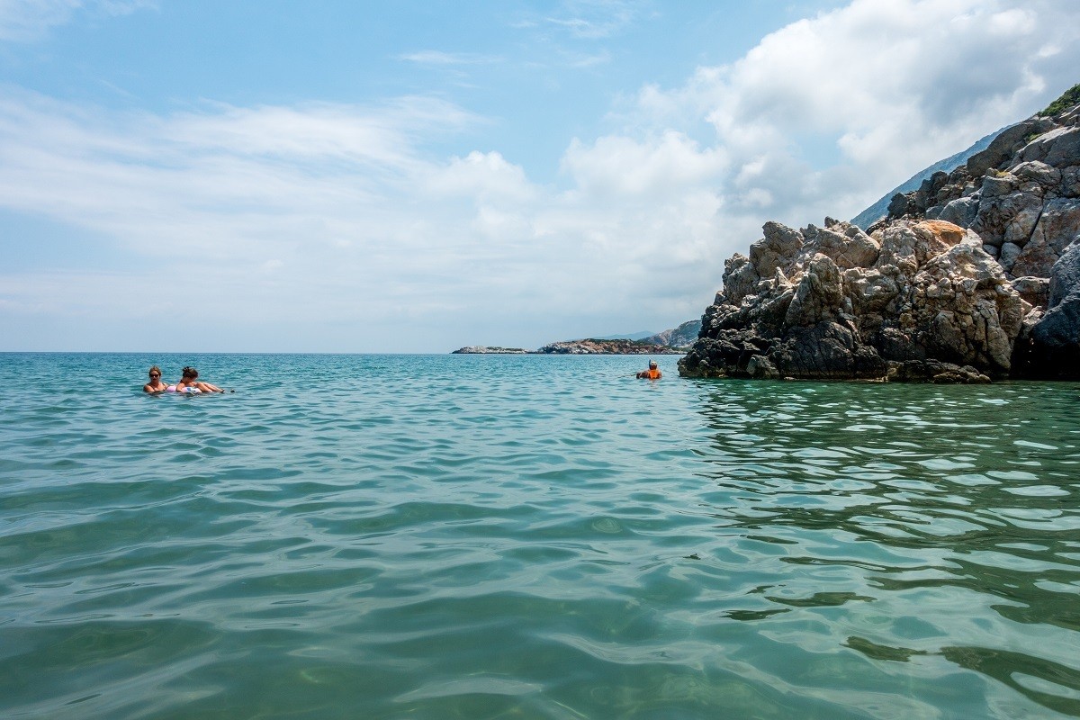 People in the ocean with rocky cliffs