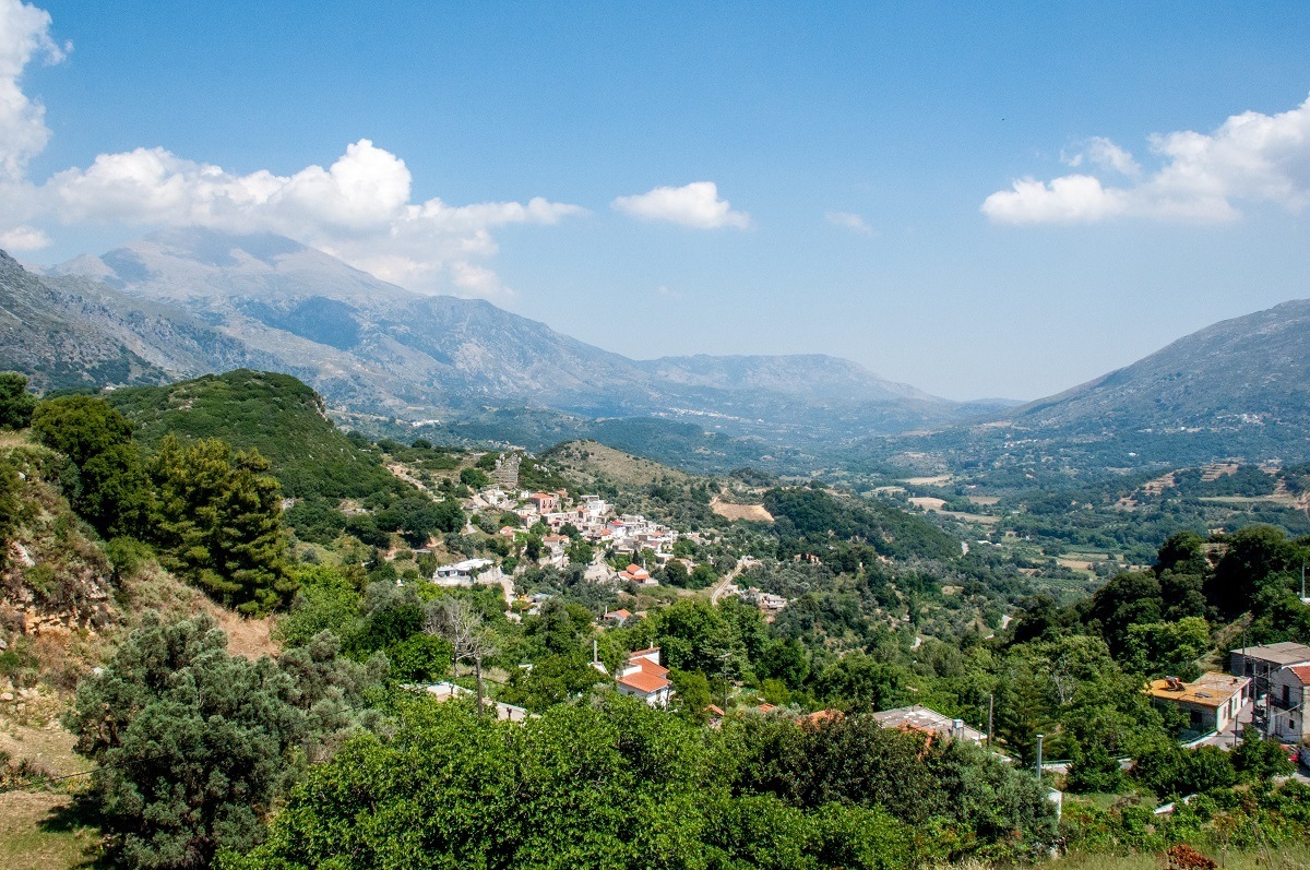 The lush, green mountains dotted with buildings in Crete