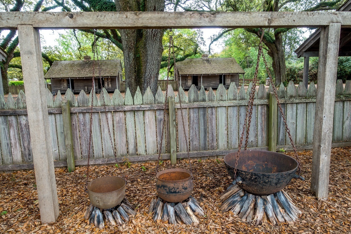 Kettles hanging over piles of firewood, the only cooking facilities for slaves
