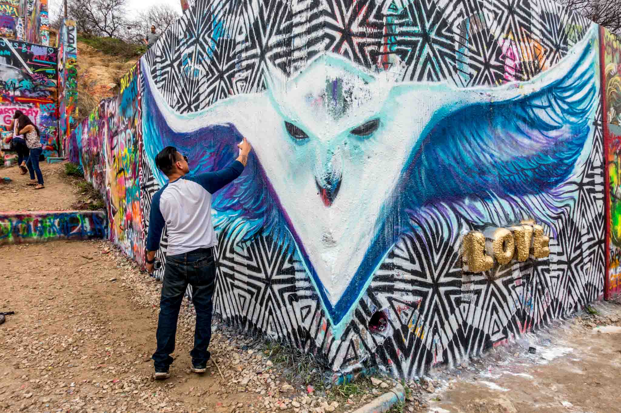 Artist spray painting a white design at HOPE Outdoor Gallery | what to see in Austin TX