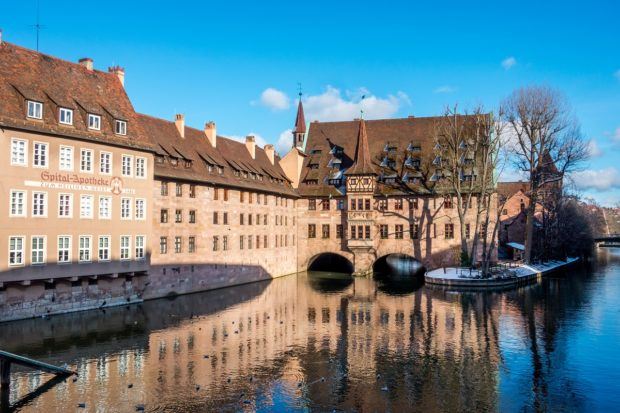 The Hospital of the Holy Spirit is a 14th-century orange brick building stretching across part of the Pegnitz River. It is one of the most photographed places in Nuremberg, Germany.