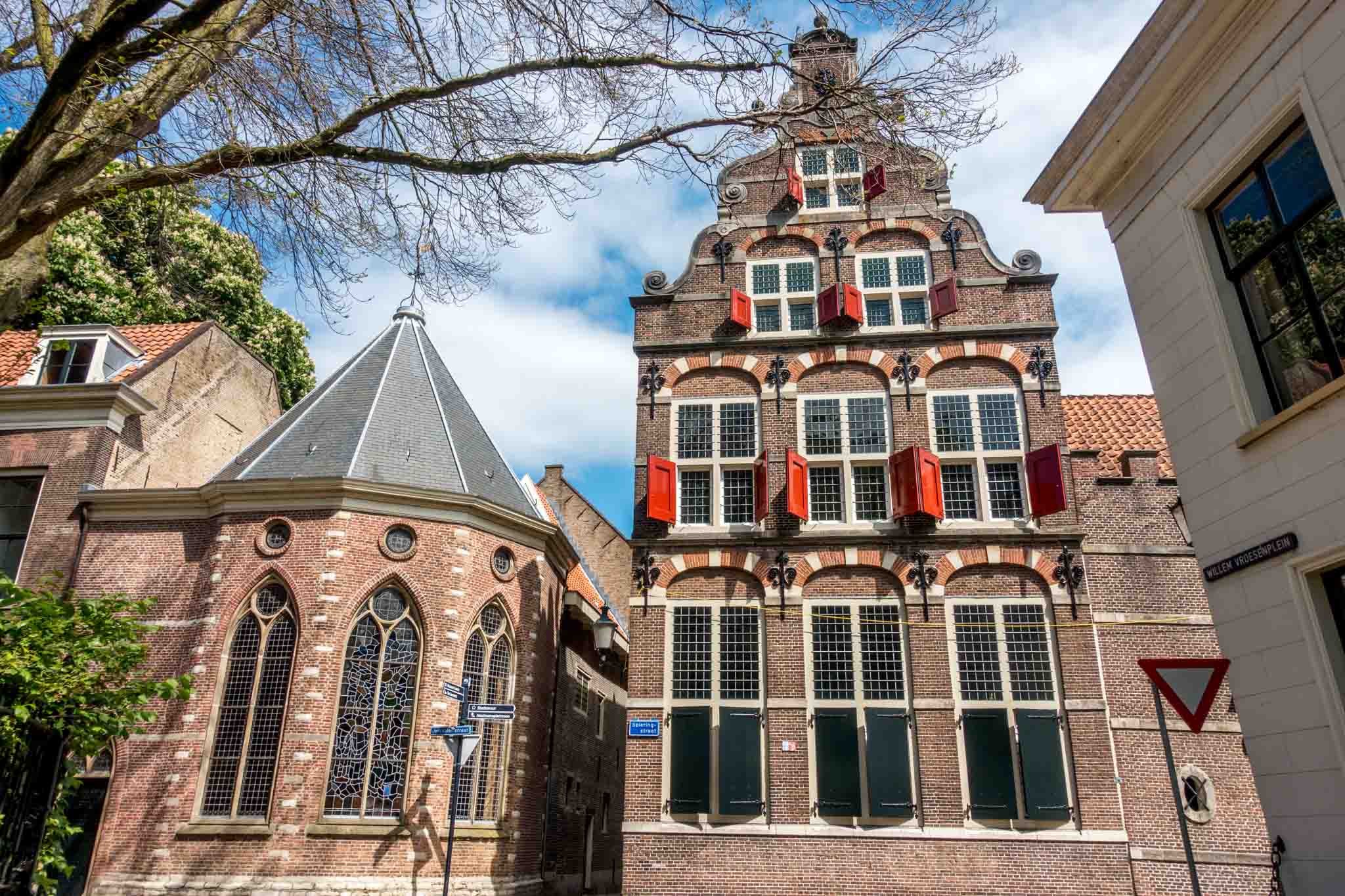 Chapel with stained glass windows and building with bright red shutters
