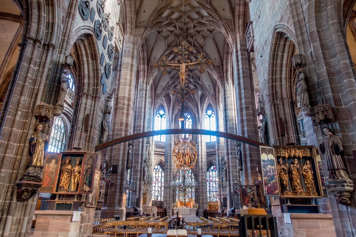 Church interior with vaulted ceilings, carvings of saints, and stained glass