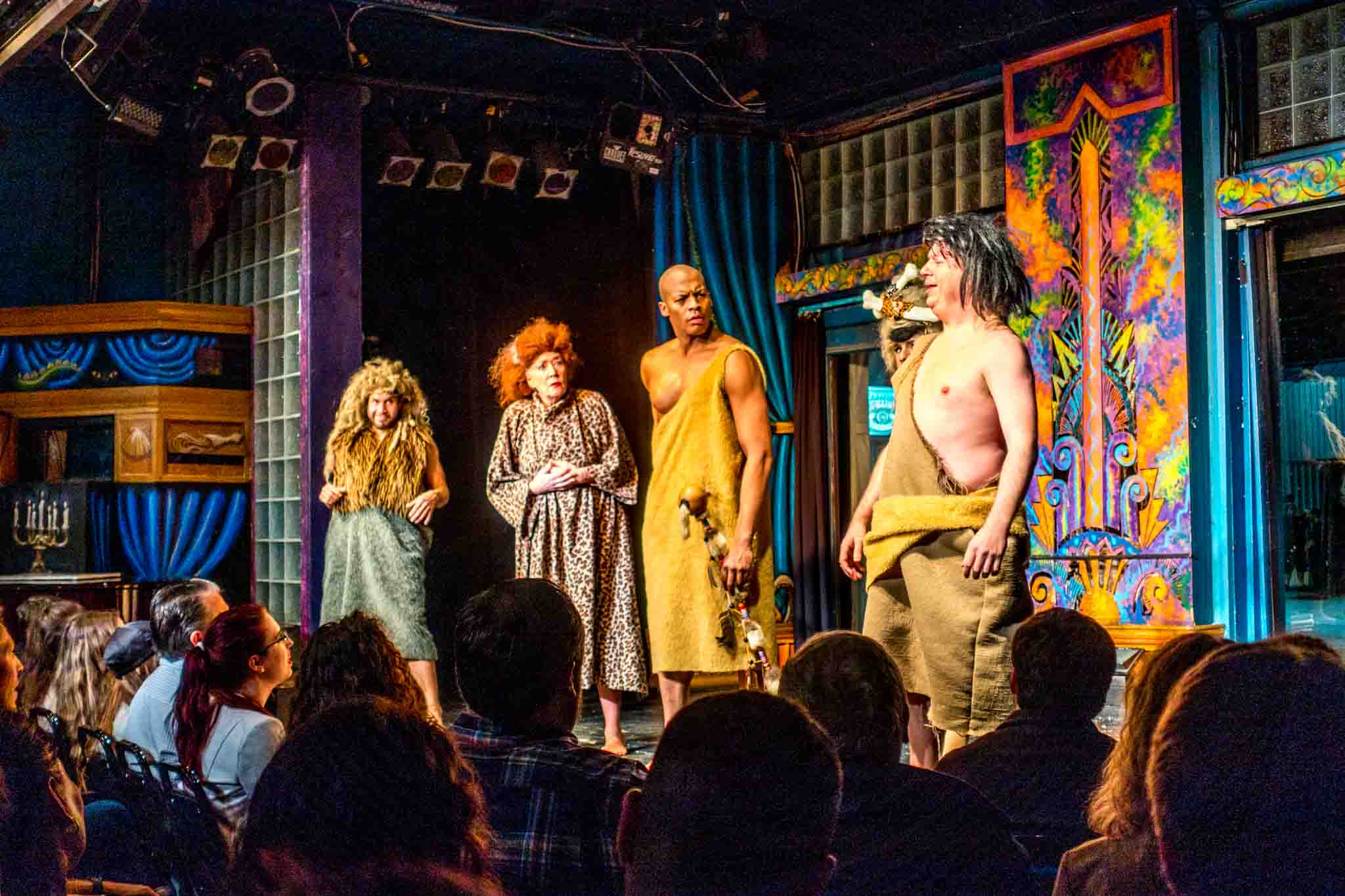 The modern-day vaudeville troupe known as Esther's Follies in a skit about cavemen. It's one of the unique shows in Austin TX.