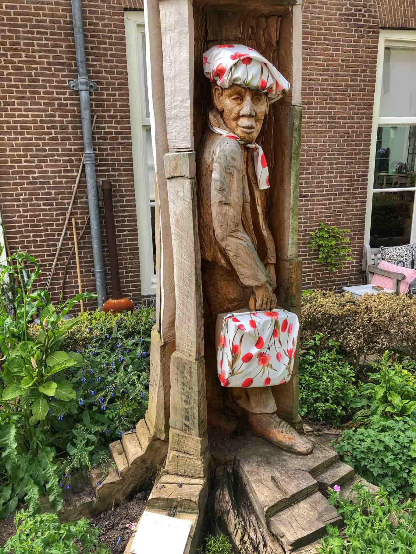 Wood carving representing a man holding a briefcase
