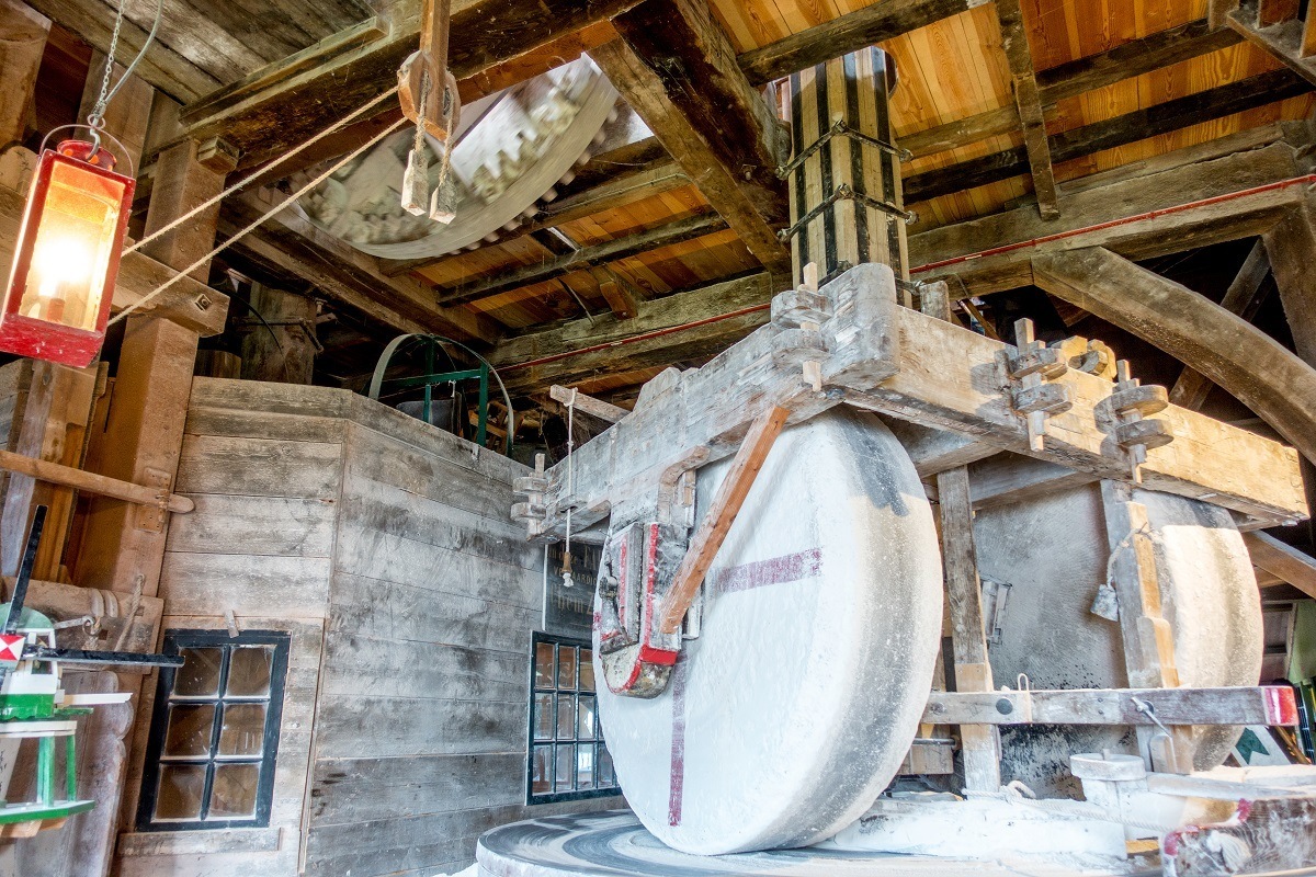 Wheels grinding chalk into powder inside De Kat windmill at Zaanse Schans Netherlands
