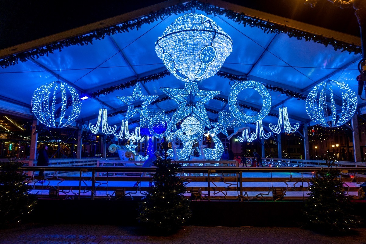 Ice skating rink trimmed with blue Christmas lights at night