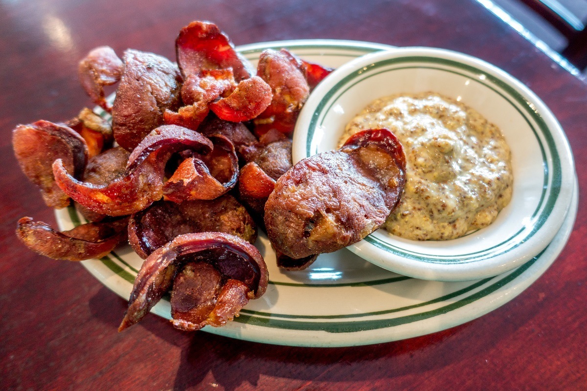 Fried andouille chips with a side of mustard