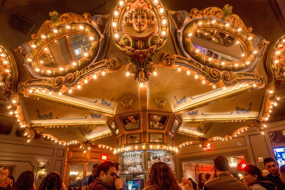 People sitting at the circular Carousel Bar in the Hotel Monteleone at night. Visiting this bar is one of the top things to do in New Orleans
