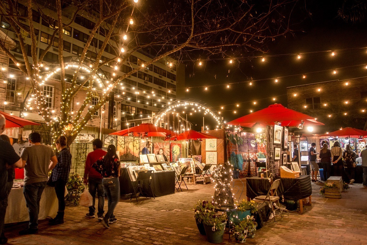 Vendors selling art in lit-up stalls at Palace Market