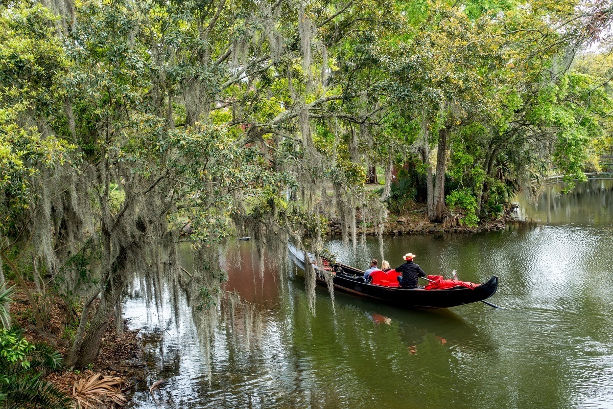Venetian gondola in a lagoon in City Park surrounded by moss-draped trees